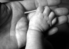 Foto con mano di neonato e mano di adulto in bianco e nero