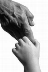 Foto in bianco e nero di mano di bimbo che stringe mano di adulto