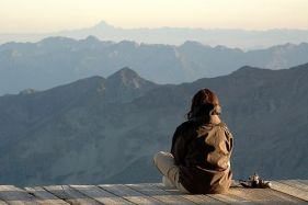 Donna che medita di fronte ad alte montagne