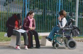 Ragazzina con disabilità insieme a due compagne di scuola
